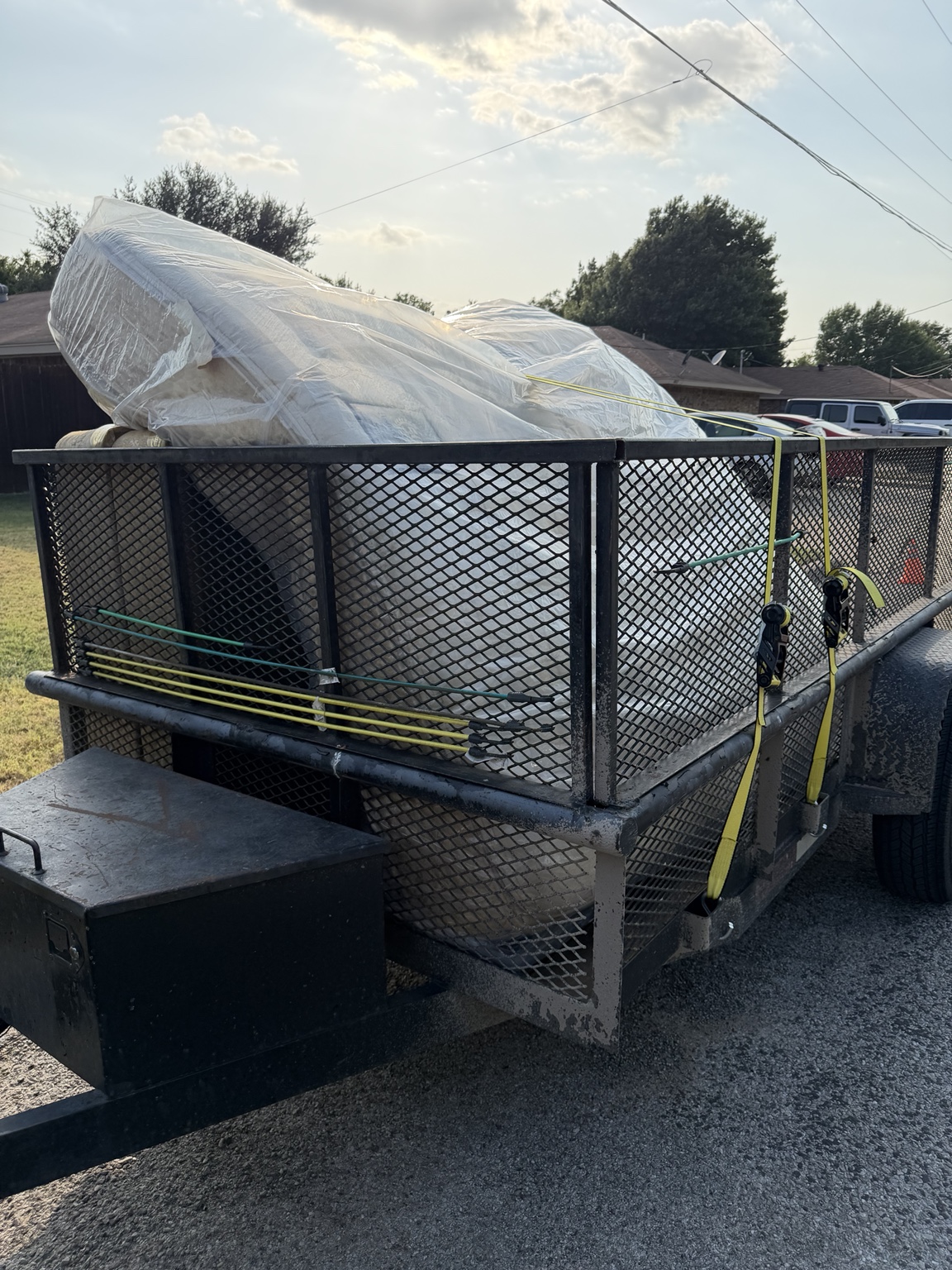 Wrapped furniture secured on a utility trailer